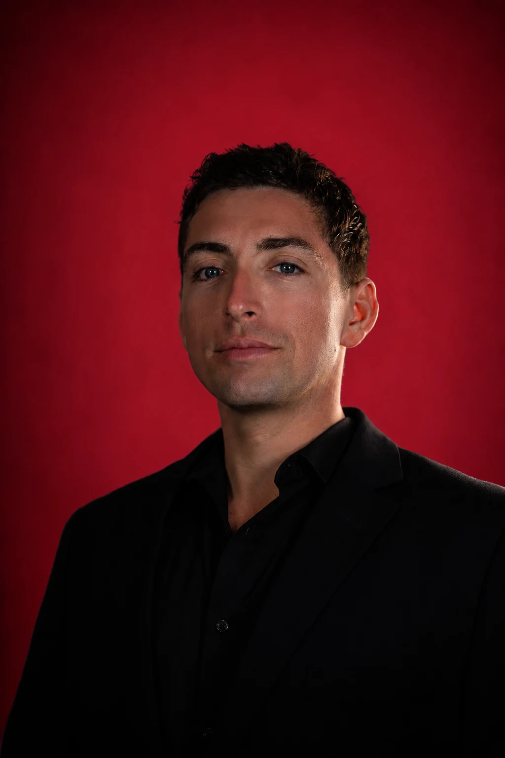 Nicholas Grande in a black suit against a red background